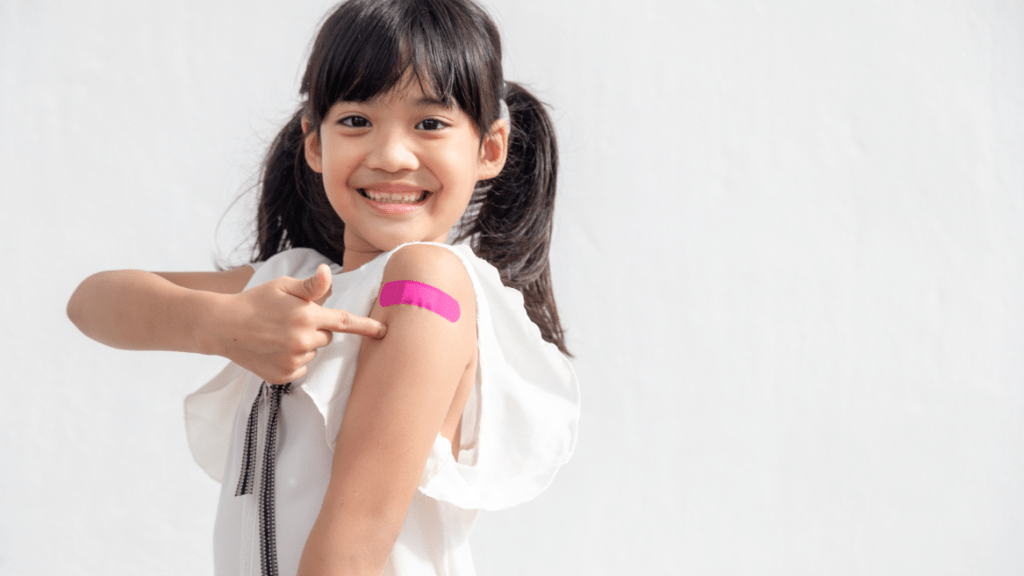 Girl with pink band-aid in a white background